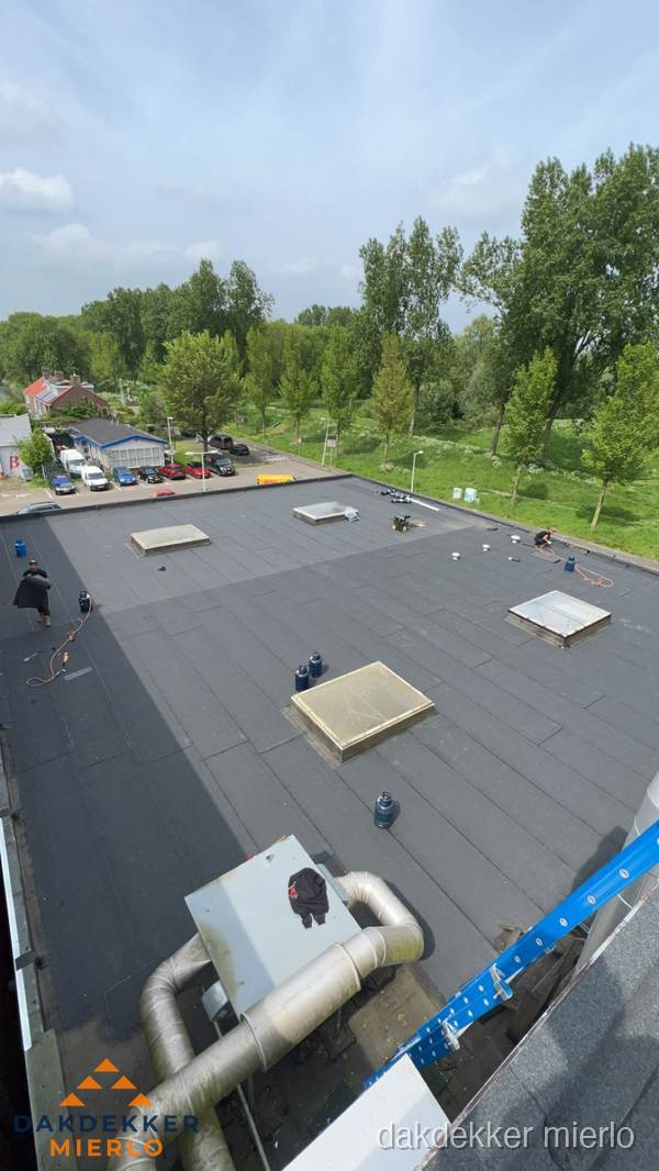 Dakdekker aan het werk op groot plat dak met bitumen in Mierlo Dakdekker aan het werk op groot plat dak met bitumen in Mierlo